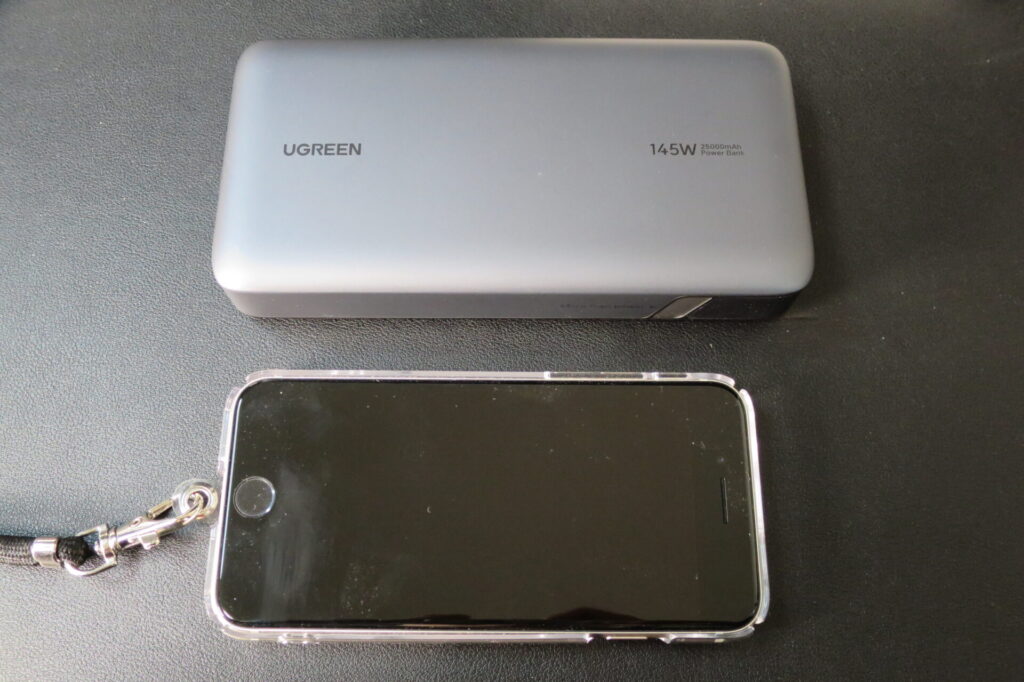 iPhoneSE 第3世代と、UGREEN PD3.1 モバイルバッテリー 145W 25000mAhを並べてサイズ比較している画像
